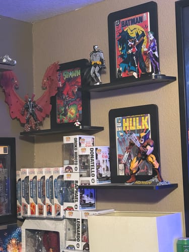 Real collector shelves with comics, Batman and Spawn displays, and figures on Nerd Hero shelves